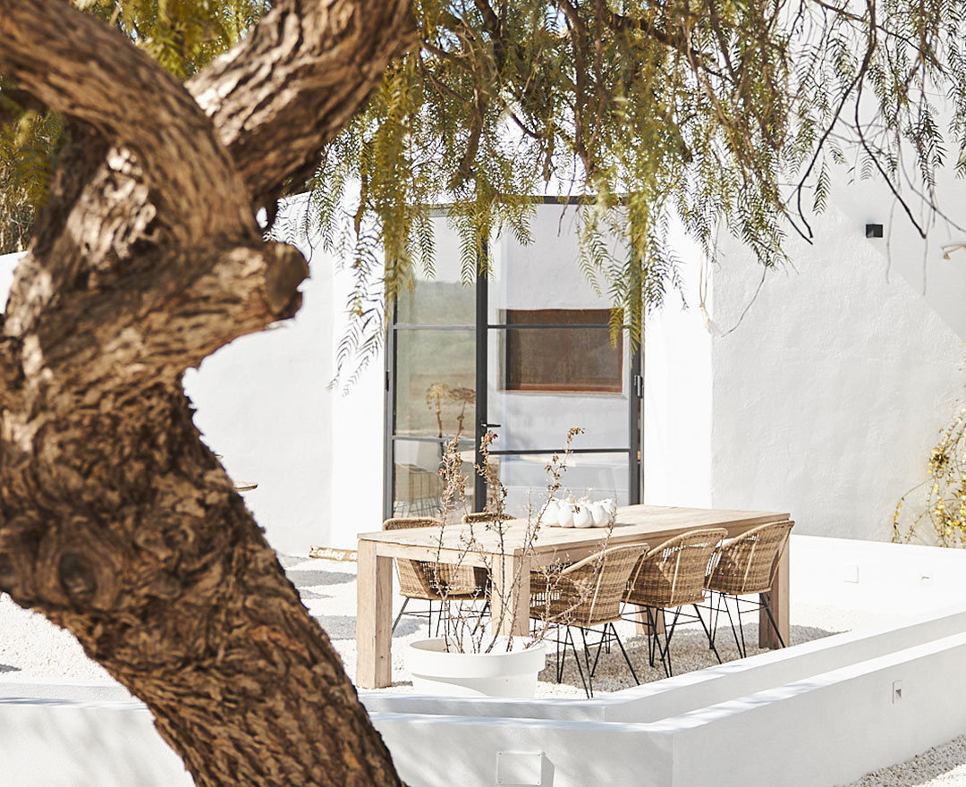 Tafel met stoelen buiten het witte huis bij Finca las Calmas